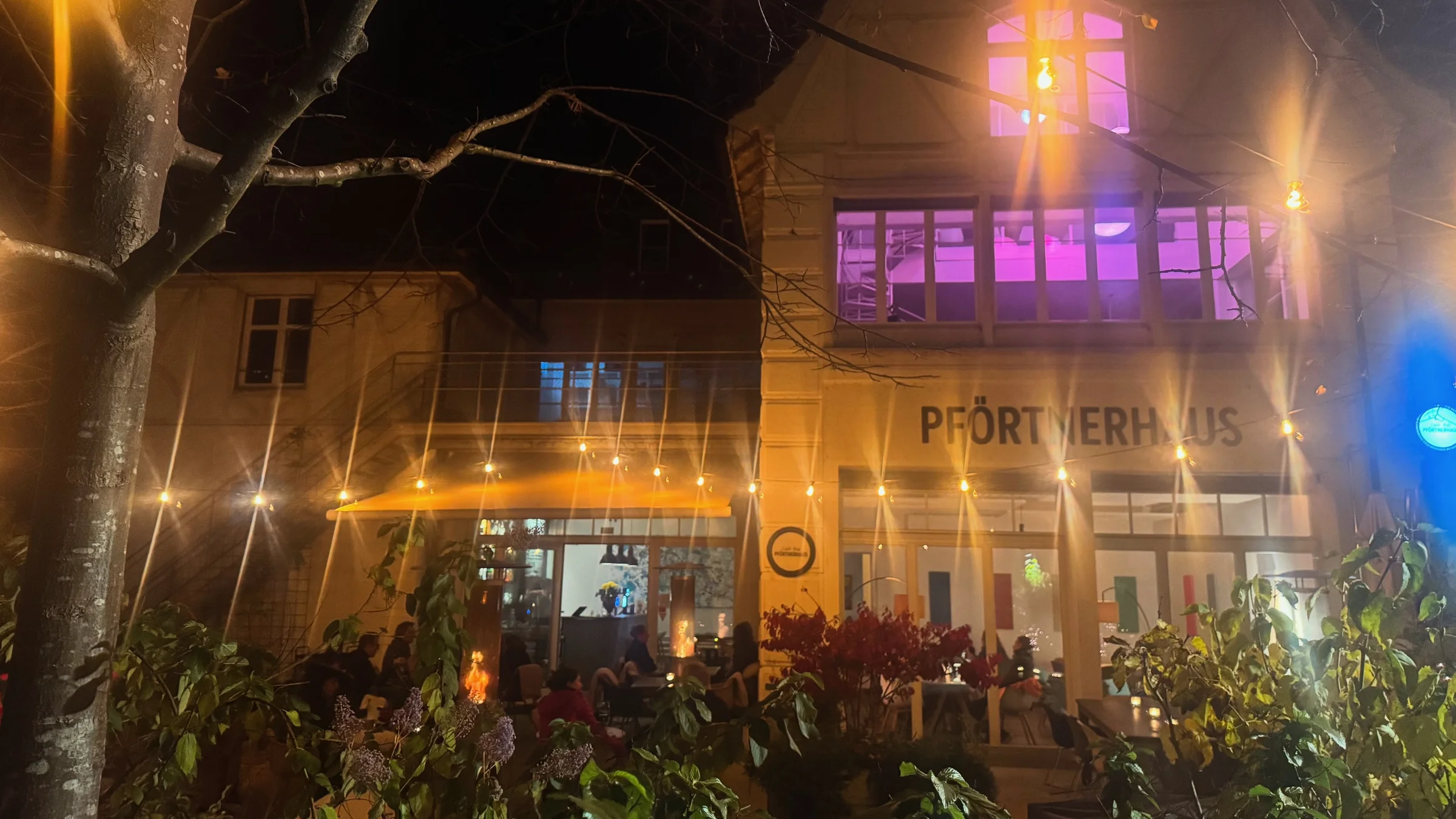 Pförtnerhaus at night with illuminated event space and garden terrace